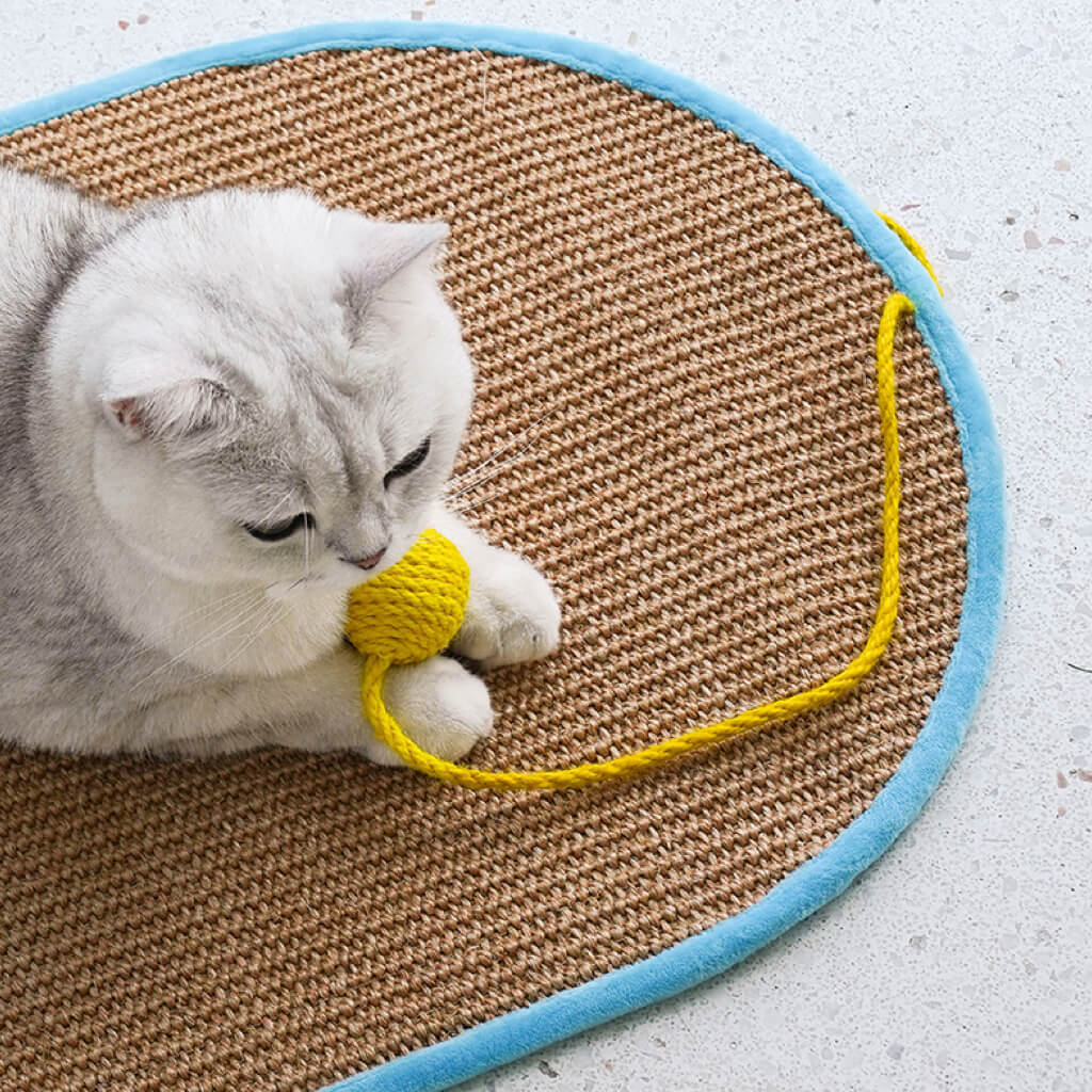 Cat playing with the yellow pom-pom on the Dopamine-Style Sisal Scratching Mat.