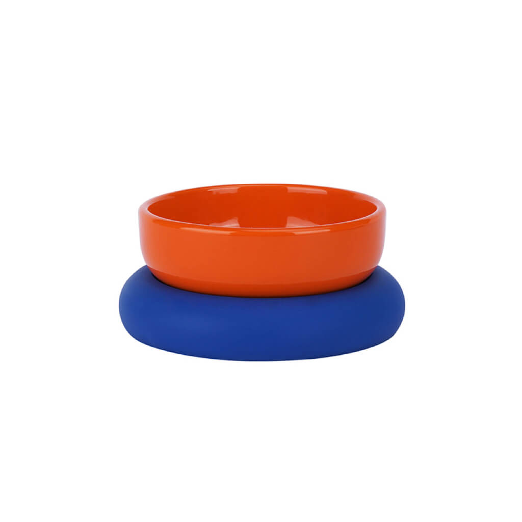 Orange glazed ceramic pet bowl on a blue food-grade silicone base.