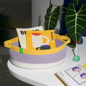Zeze handwoven pet basket used as a stylish storage container for books and magazines.