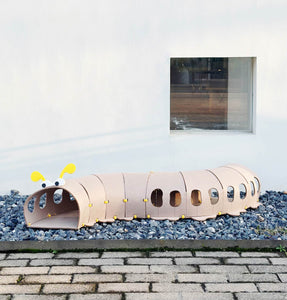 Outdoor view of the beige felt tunnel toy setup on a patio.