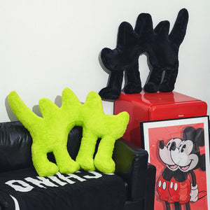 Fluo Green Boom Boom Cat Cushion with a black Boom Boom Cat Cushion on a red side table.
