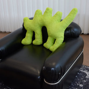 Fluo Green Boom Boom Cat Cushion on a black leather armchair.