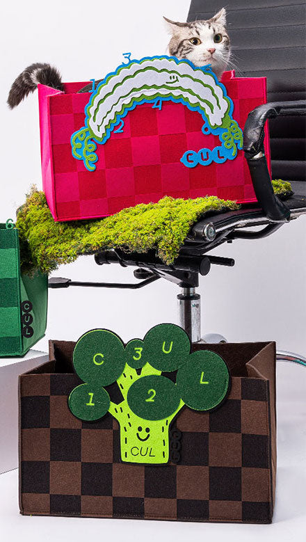 Adorable cat relaxing in a cozy felt bed, adorned with creative patterns.