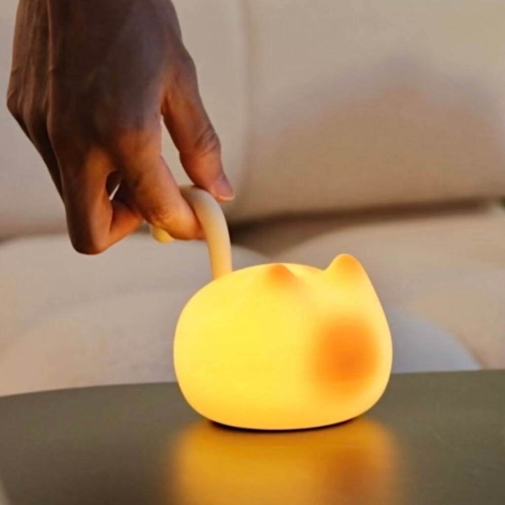 Lifting by the curl-tail handle — cordless cat night light, easy carry, USB-C rechargeable.