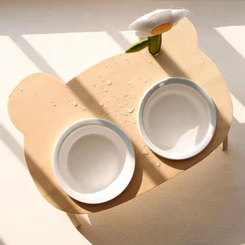 Close-up of the Daisy Flower Standing Pet Bowl with water droplets on the waterproof wooden surface and ceramic bowls.