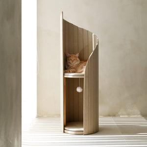 Ginger cat peacefully resting on the top platform of the beige Time Travel Cat Tower, with sunlight streaming through the room.