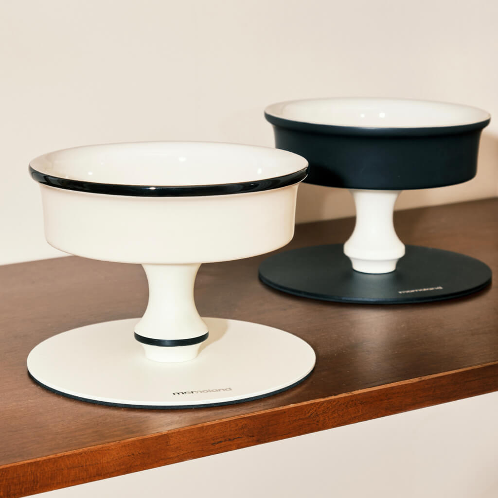 Bamboo Island elevated ceramic pet bowls in black and white on wood shelf; minimalist pedestal cat & dog feeders.
