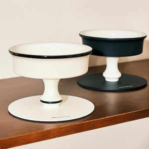 Bamboo Island elevated ceramic pet bowls in black and white on wood shelf; minimalist pedestal cat & dog feeders.