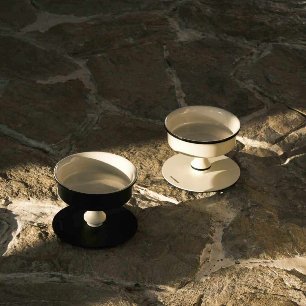 Black and white Bamboo Island elevated ceramic pet bowls in natural light; stable pedestal feeders.