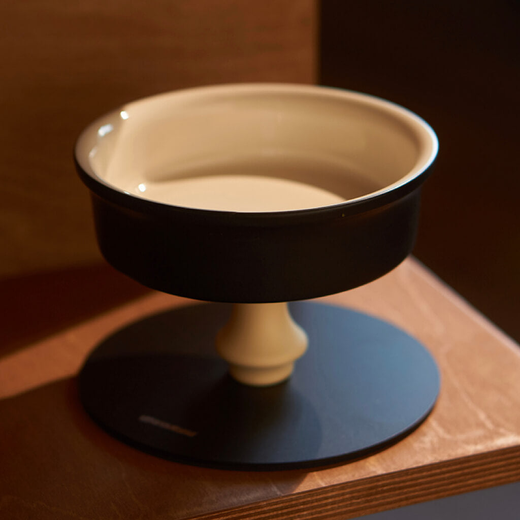 Single black elevated ceramic cat bowl on pedestal stand—modern, detachable design for easy cleaning.