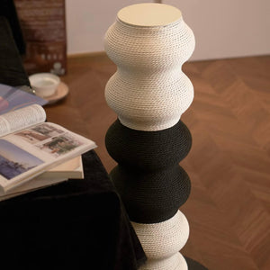 Top view of the Coral Cat Scratcher beside books, showing flat cap and stacked wavy modules — black & white.
