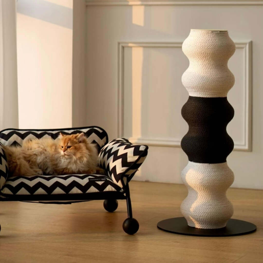 Bicolor Coral Cat Scratcher next to a lounging cat—minimalist wavy design fits stylish living rooms.