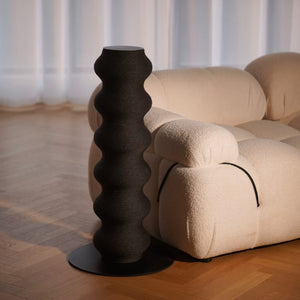 Sleek Black Cat Scratcher Next to a Cozy Sofa – A premium cat scratching post that seamlessly blends into contemporary and minimalist home decor.