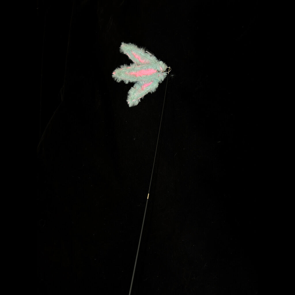 A pale color bamboo leaf-shaped attachment hanging from the bamboo cat teaser, set against a dark backdrop, ready for playful interaction with your feline.