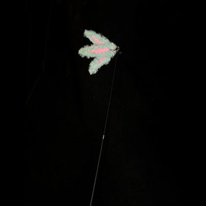 A pale color bamboo leaf-shaped attachment hanging from the bamboo cat teaser, set against a dark backdrop, ready for playful interaction with your feline.