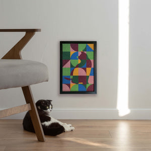 Cat seated next to an abstract, colorful, geometric cat-themed sisal scratcher mounted on the wall, inspired by the artwork of Paul Klee, blending artistic home decor with functionality.