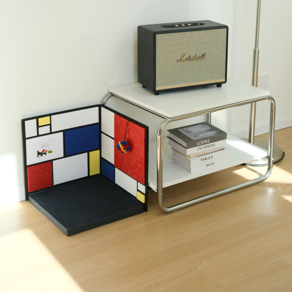 L-shaped Mondrian-inspired corner cat scratcher tucked under side table — non-slip base and hanging toy shown.