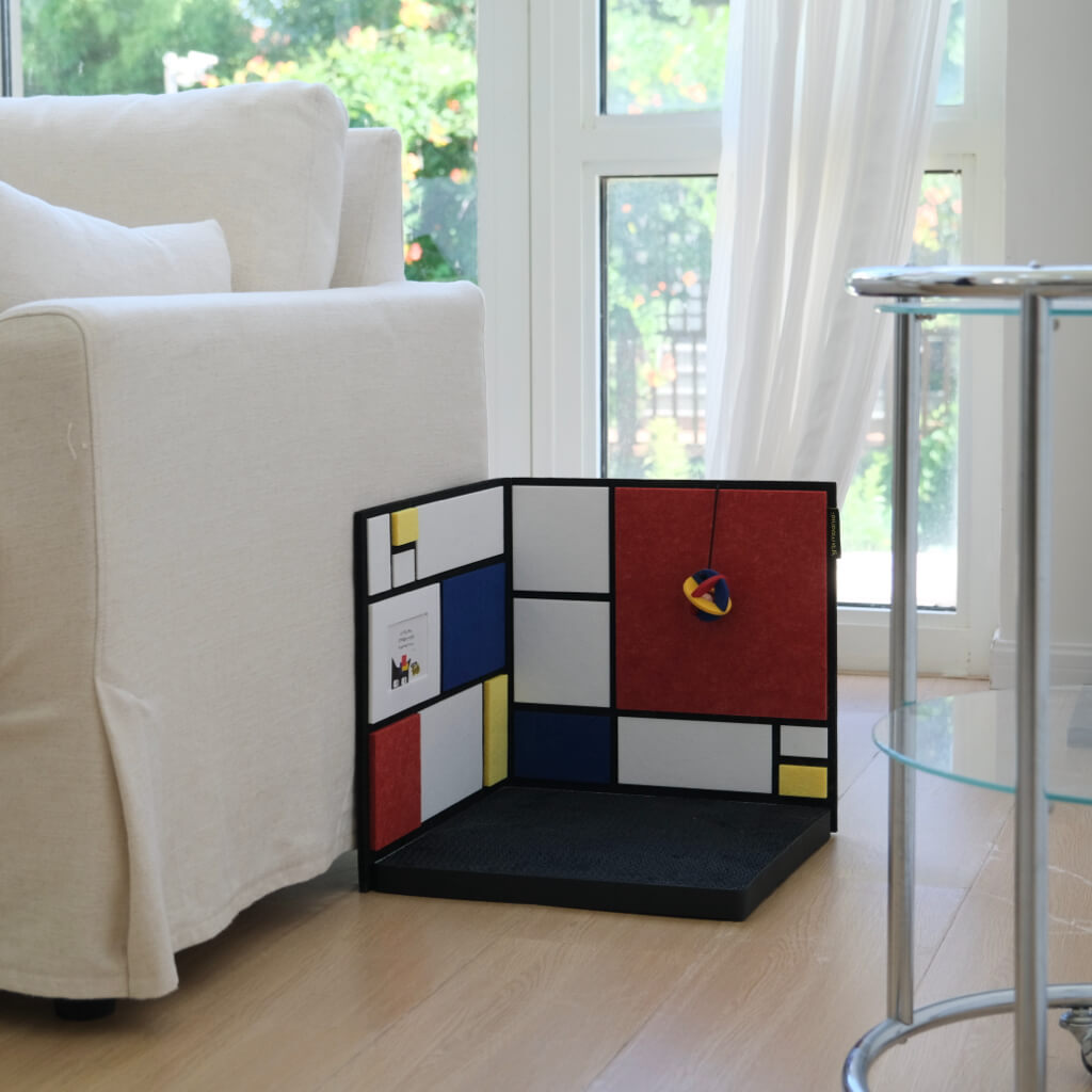 Corner cat scratcher beside sofa near window — protects walls and furniture; L-shaped, decor-friendly design.