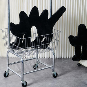Boom Boom Cat Cushion Black placed in a wire shopping basket with other similar cushions.