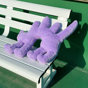 Boom Boom Cat Cushion in purple resting on a white park bench.