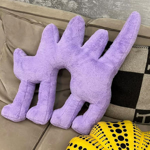 Plush purple Boom Boom Cat Cushion on a gray couch with artistic pillow.