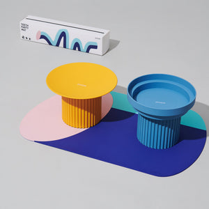 Minimalist Chroma Party Pet Dining Mat alongside colorful pet bowls.