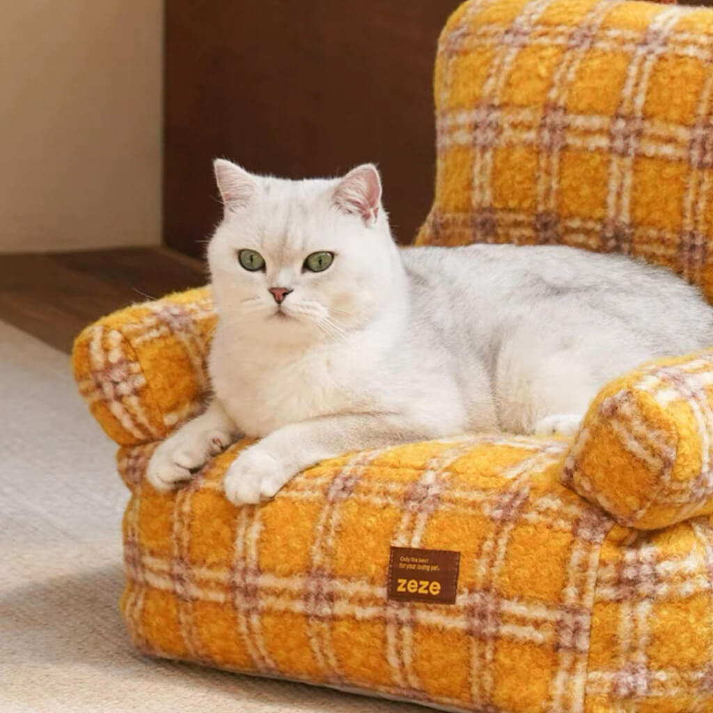 Close view of yellow plaid cat armchair bed showing soft bolsters and textured fabric.