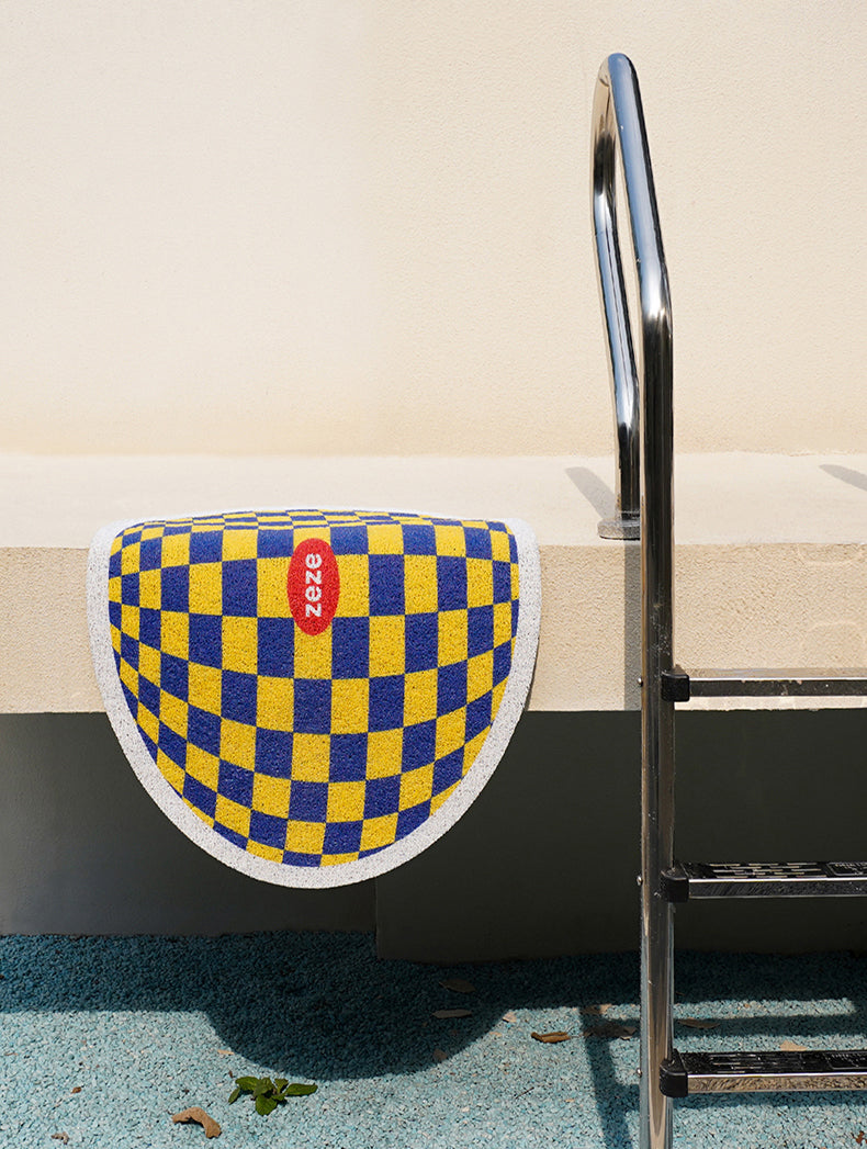 Yellow and Blue Design Plaid Litter Mat Displayed Near a Poolside Area.