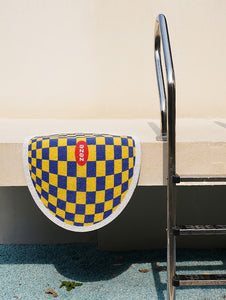 Yellow and Blue Design Plaid Litter Mat Displayed Near a Poolside Area.