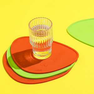 Close-up of stackable red and green silicone drink coasters.