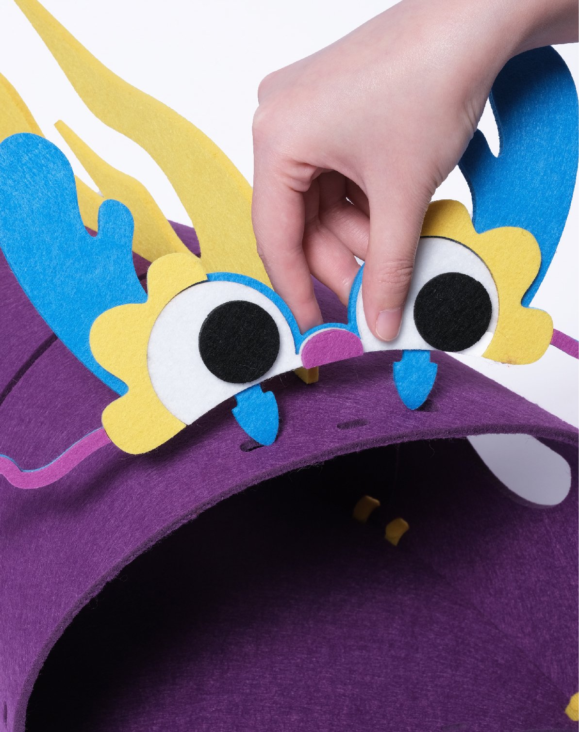 Close-up of hands assembling the felt dragon tunnel toy - Design Felt Cat Tunnel Assembly.