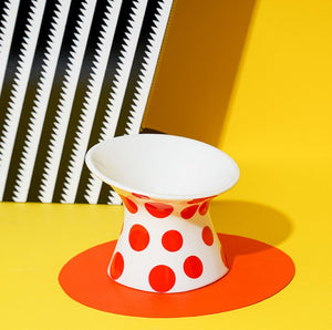 Single ZEZE Elevated Ceramic Bowl - Red Polka Dots with vibrant decor in the background.