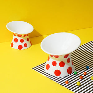 Two sizes of the ZEZE Elevated Ceramic Bowl - Red Polka Dots displayed with striped decor.
