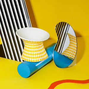 Yellow rhombus patterned ZEZE Elevated Ceramic Bowl, placed on a decorative surface for modern pet feeding.